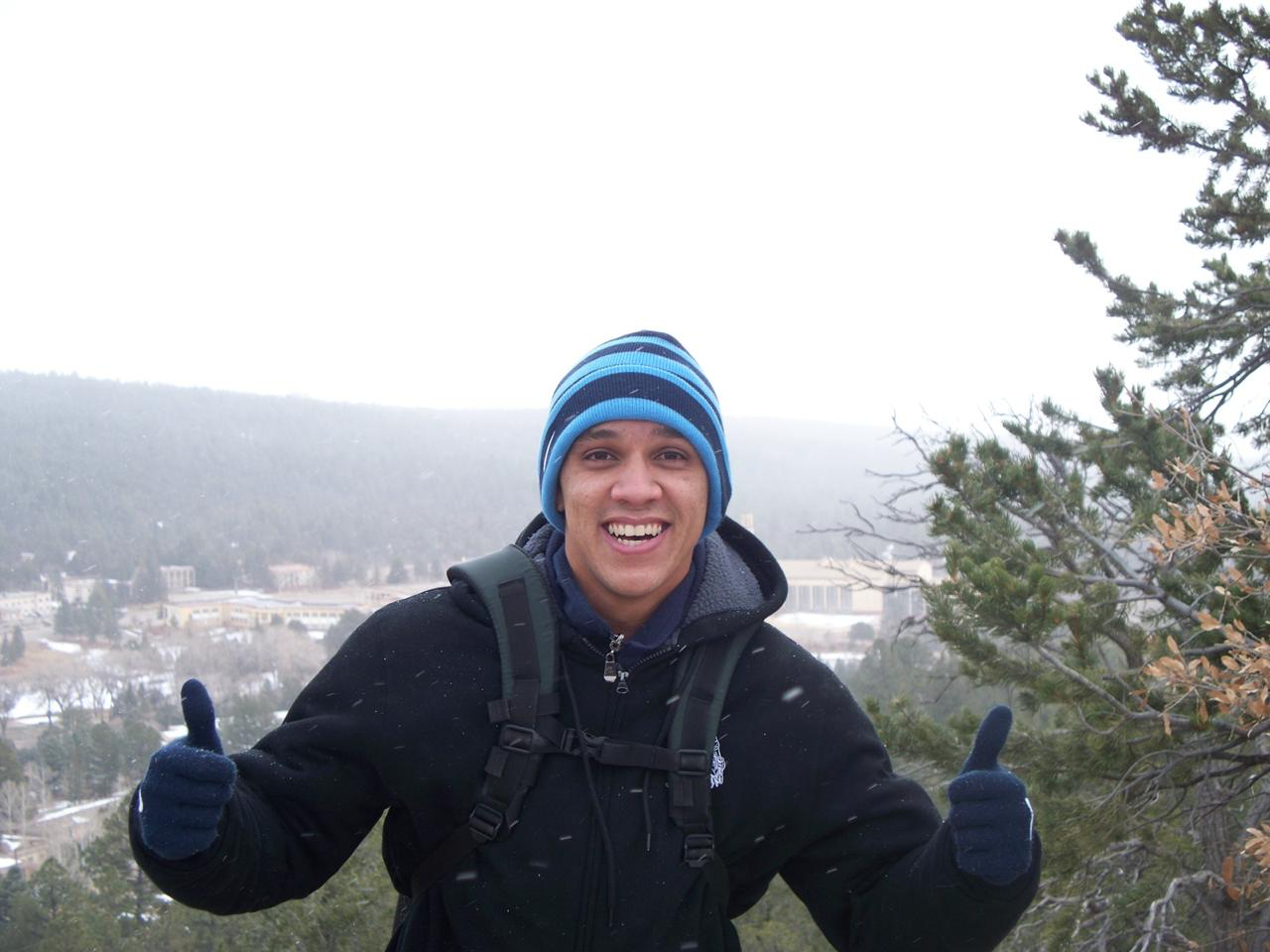 Ruan França em um mirante nevado nos Estados Unidos com os polegares para cima